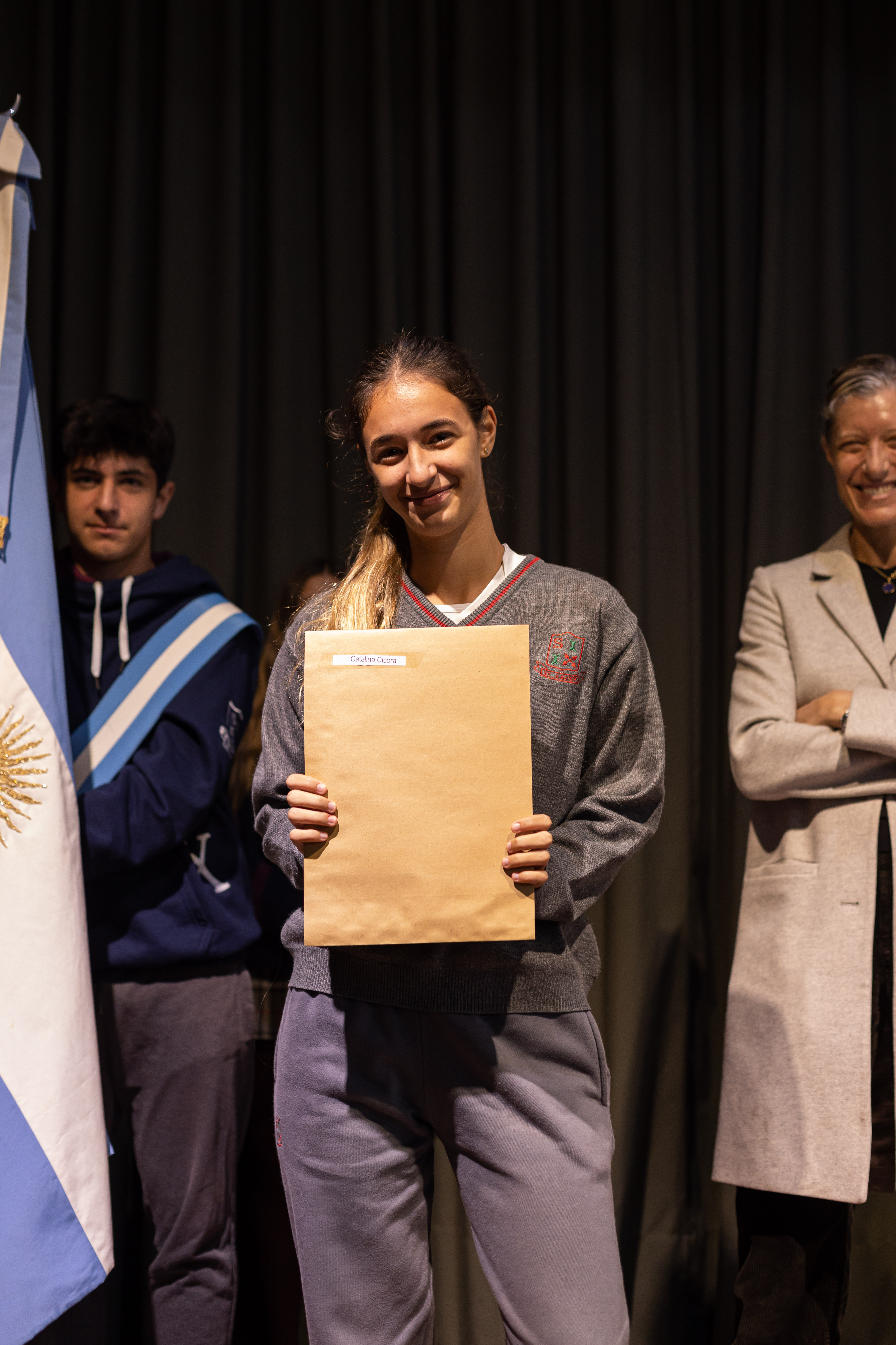 Alumna secundaria del Colegio San Javier sonriendo con su diploma en un acto de entrega de certificaciones