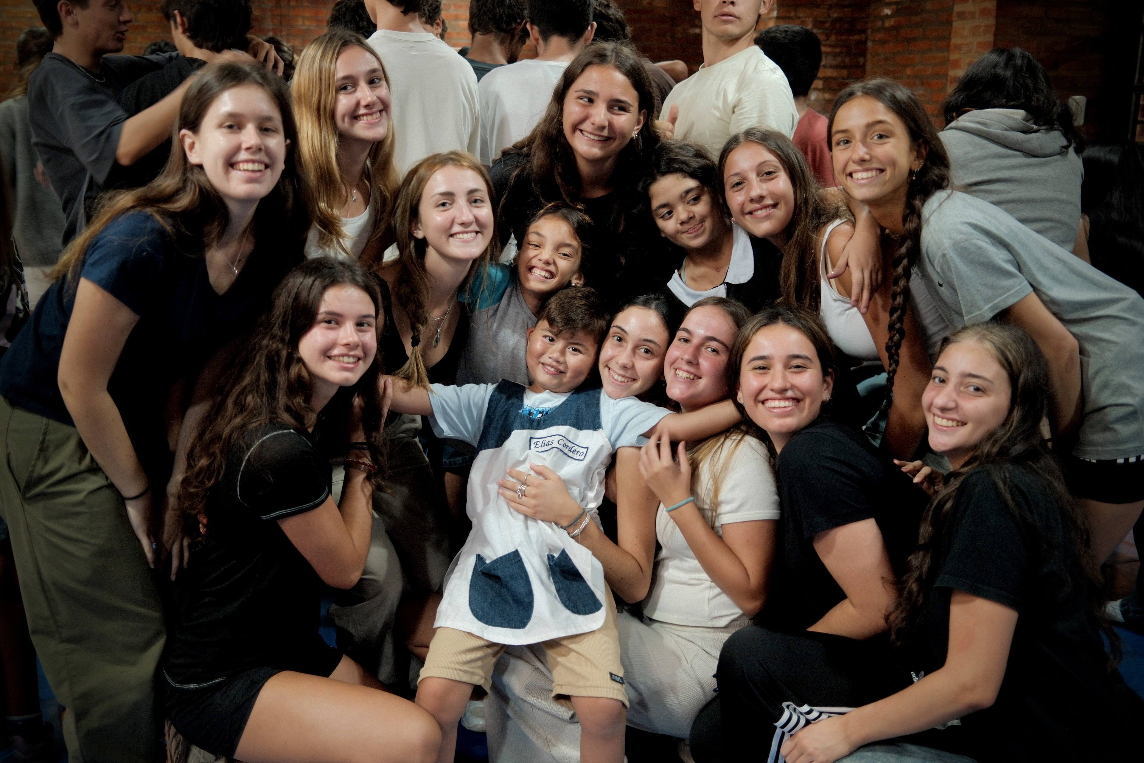Alumnos secundarios del Colegio San Javier sonriendo abrazados durante la Misión en el barrio Magdalena