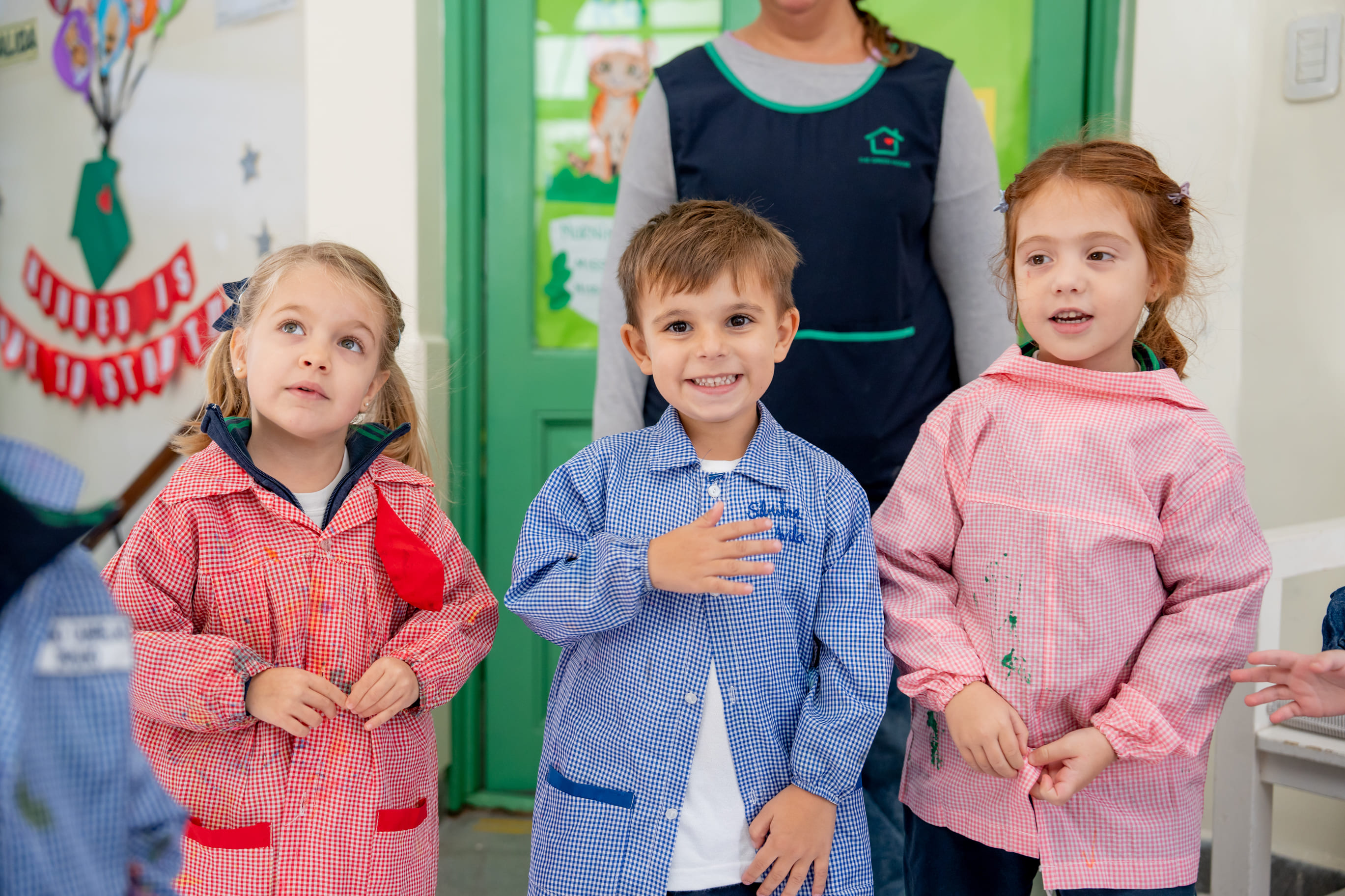 Alumnos de la sala de Jardín The Green House Kindergarten con guardapolvos en el aula