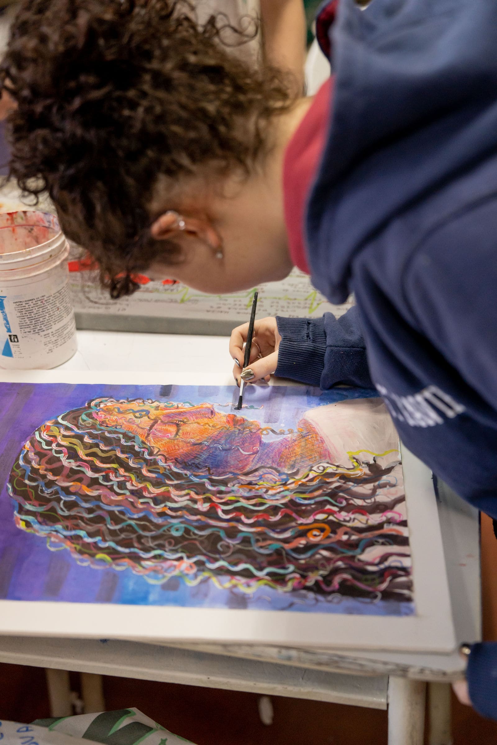 Alumna secundaria pintando un retrato con témperas en el taller de arte del Colegio San Javier